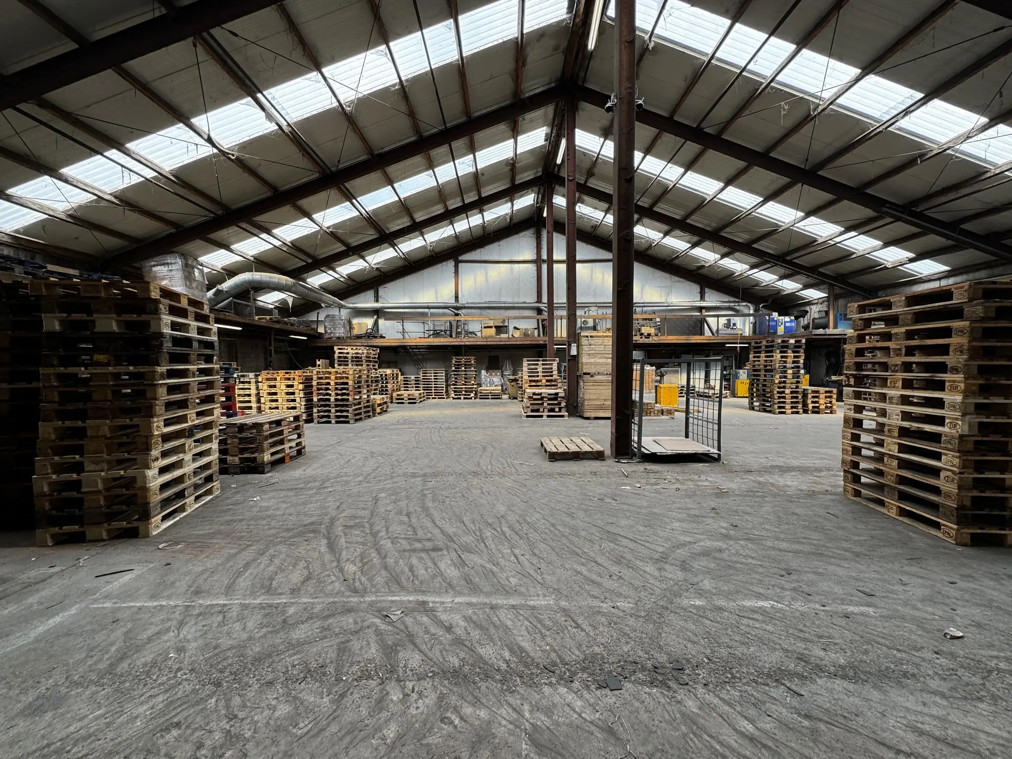 Grote loods aan de Graaf van Lynden van Sandenburgweg volgestapeld met houten pallets.